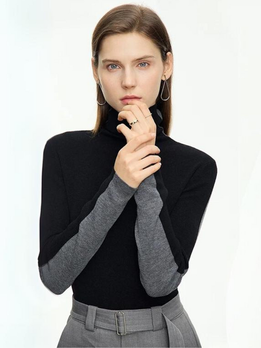 A woman wearing a dual toned black and gray turtleneck sweater that is interchangeable to achieve two looks.